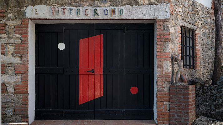 Porta d’ingresso del Pittocromo, il laboratorio di Brajo Fuso, su una facciata in mattoni