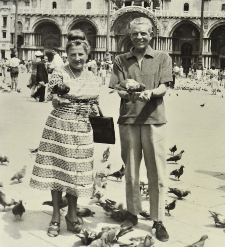 foto a figura intera di Bettina e Brajo Fuso sorridenti in piazza San Marco a Venezia mentre danno da mangiare ai piccioni